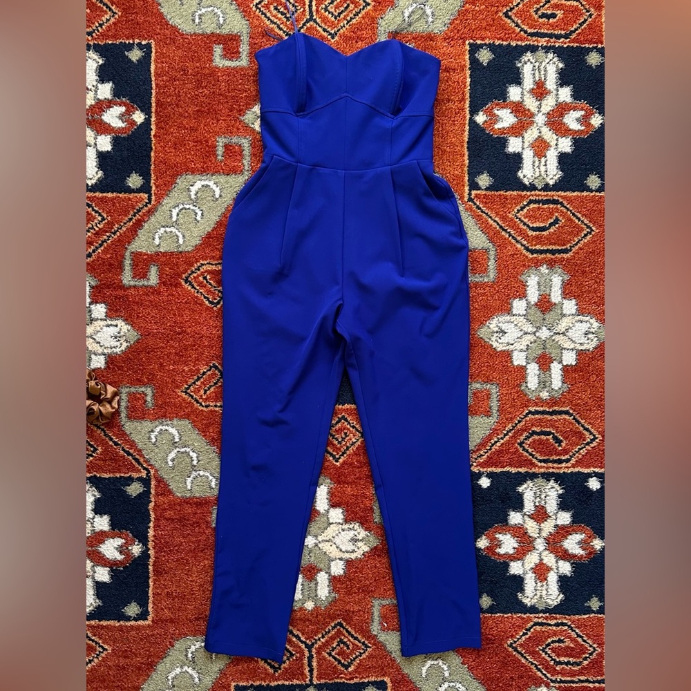 Strapless blue jumpsuit with pleated pants.
